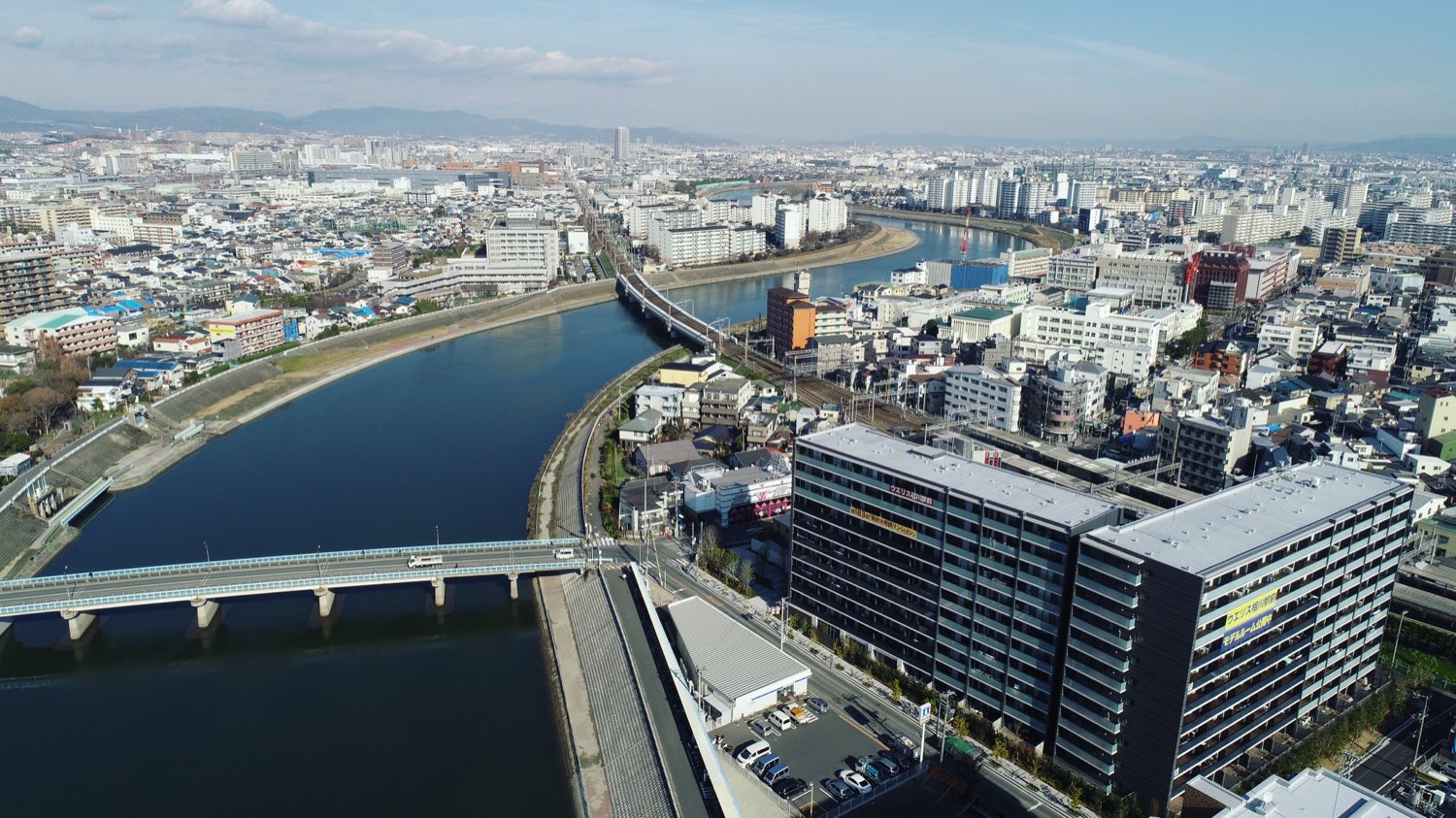 河川に架かる橋と市街地を上空から捉えた空撮写真